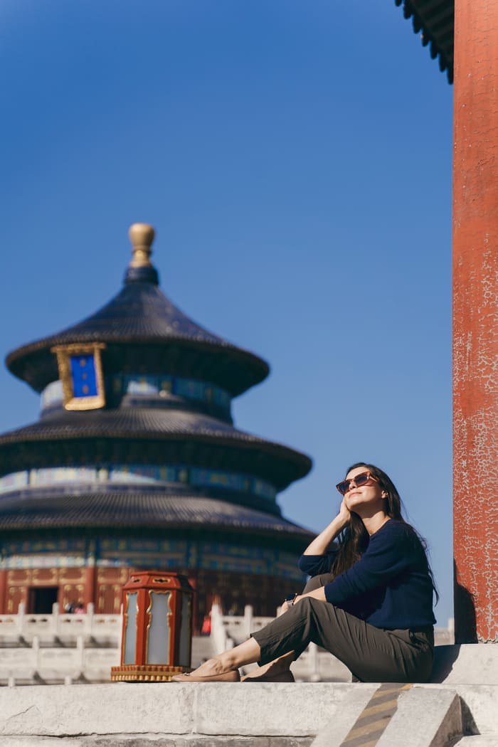 chica sentada en la ciudad de beijing con el fondo de un templo tradicional chino
